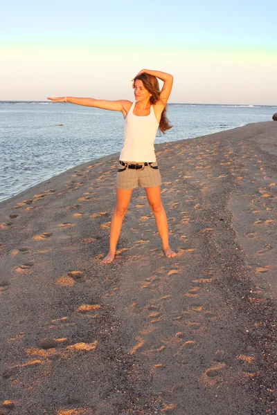 年轻女子在海滩上做瑜伽 — 图库照片