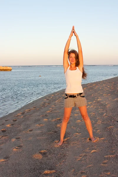 Flickan gör yoga nära havet — Stock fotografie