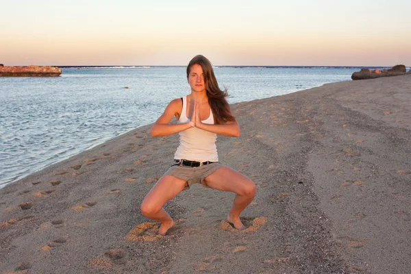 Deniz kenarında yoga yaparken kız — Stok fotoğraf