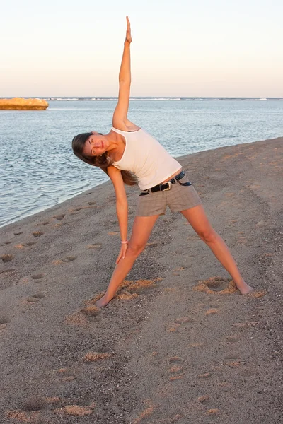 Piękna dziewczyna robi joga w pobliżu morza — Zdjęcie stockowe