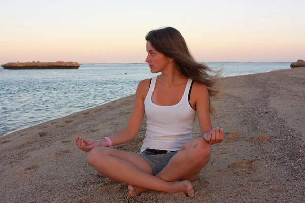 Deniz kenarında yoga yaparken kız — Stok fotoğraf