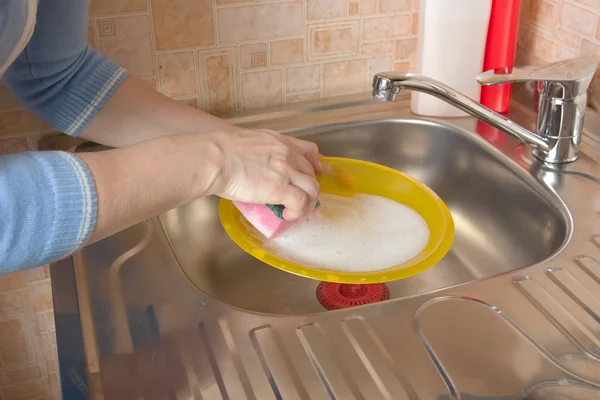 Mujer lavando platos en su cocina —  Fotos de Stock