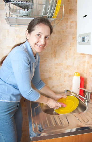Woman washes ware on kitchen — Stock Photo, Image