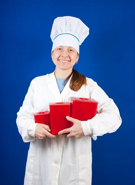 Senior female cook with packages — Stock Photo, Image
