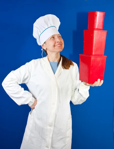 Female cook with red plastic packages — Stock Photo, Image