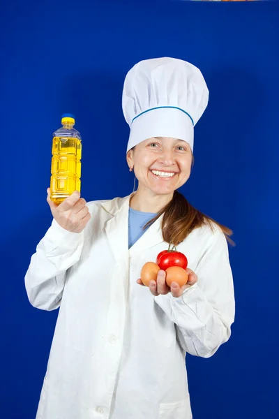 Female cook with different foods — Stock Photo, Image