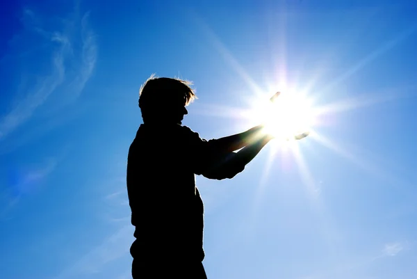 Человек берет солнце в руки — стоковое фото