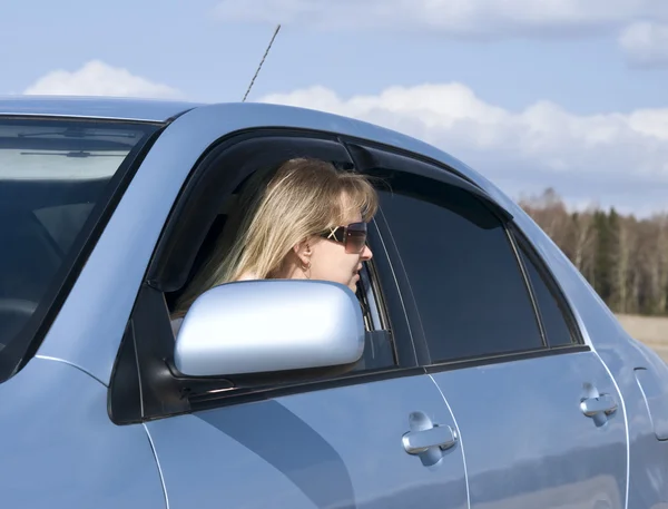 Looking in the window of her car — Stock Photo, Image