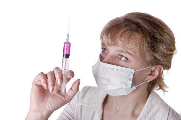 Jonge verpleegster in masker met spuit — Stockfoto