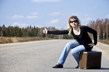 Country girl hitchhiking on the road clipart