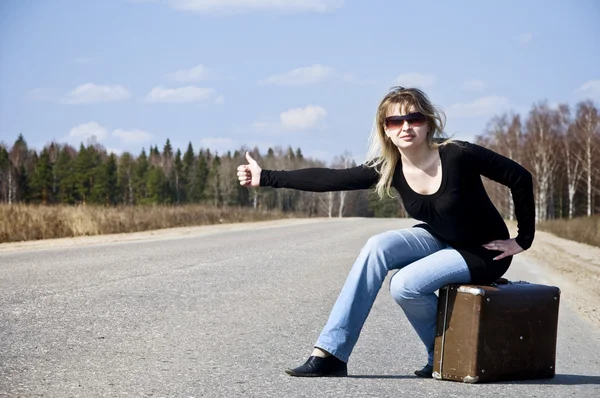 stock image Country girl hitchhiking on the road