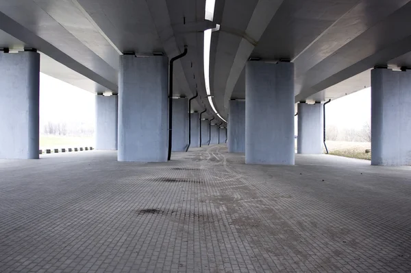 Вид на дорогу под бетонным автомобильным мостом — стоковое фото