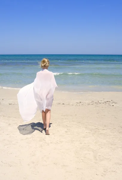 Kobieta na plaży z białym sarong — Zdjęcie stockowe