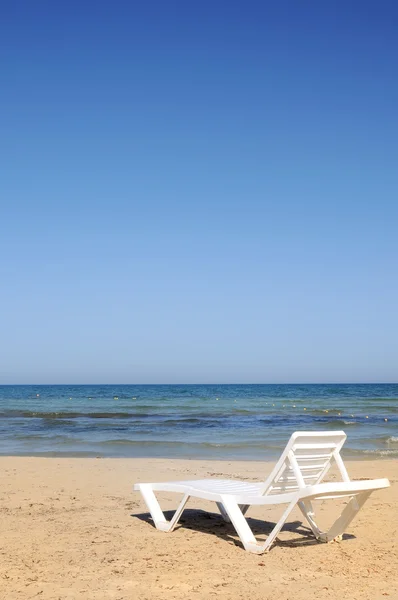 Liegestühle am Strand unter blauem Himmel — Stockfoto