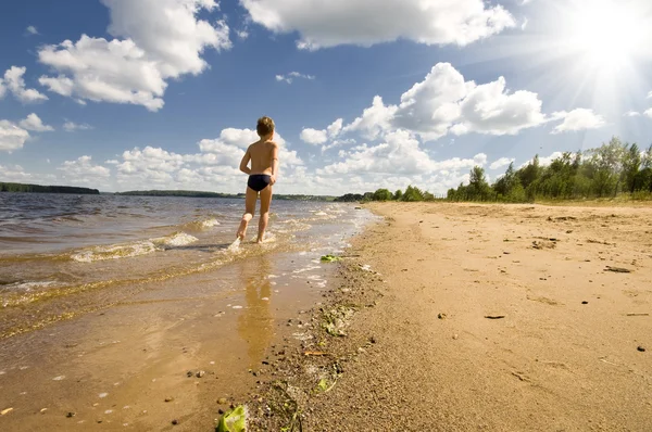 아름 다운 해변에서 실행 하는 어린 소년 — 스톡 사진
