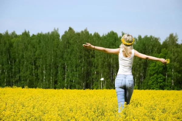 Happy young woman is standing on a field — Stock Photo, Image