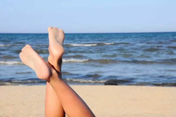 Lovely legs on the beach on sky — Stock Photo, Image