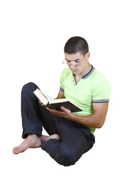 Junger Kerl sitzt und liest ein Buch — Stockfoto