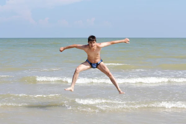 Menino pulando na praia — Fotografia de Stock