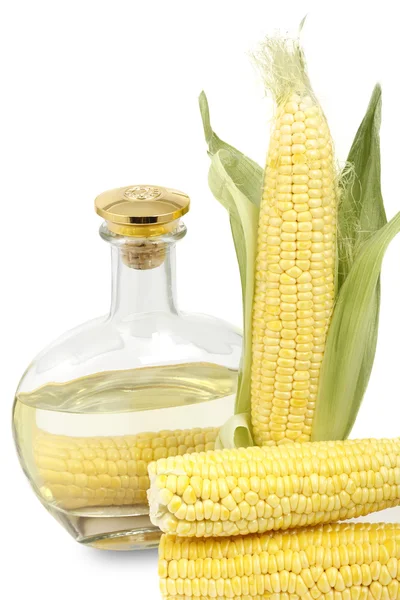 Mais sulla pannocchia e una bottiglia di olio di mais — Foto Stock
