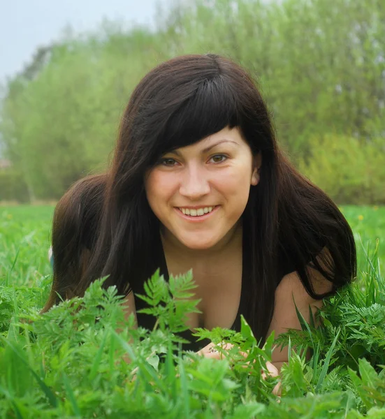 Sorridente bella donna sdraiata sull'erba — Foto Stock