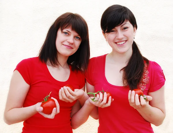 Two happy young woman with tomatoes — Stock Photo, Image