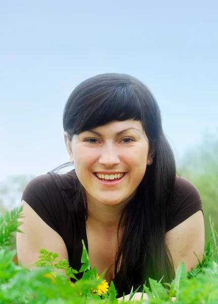 Smiling beautiful woman laying on grass — Stock Photo, Image