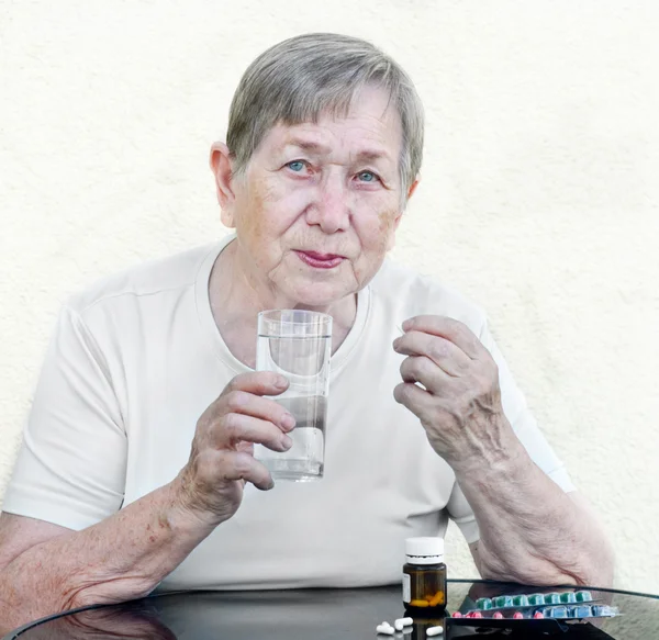 A mulher idosa aceita comprimidos — Fotografia de Stock