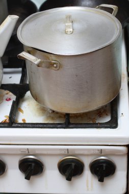 Pan on old dirty gas stove clipart