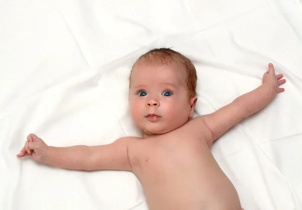 白いシートの上に横たわる赤ちゃん — ストック写真