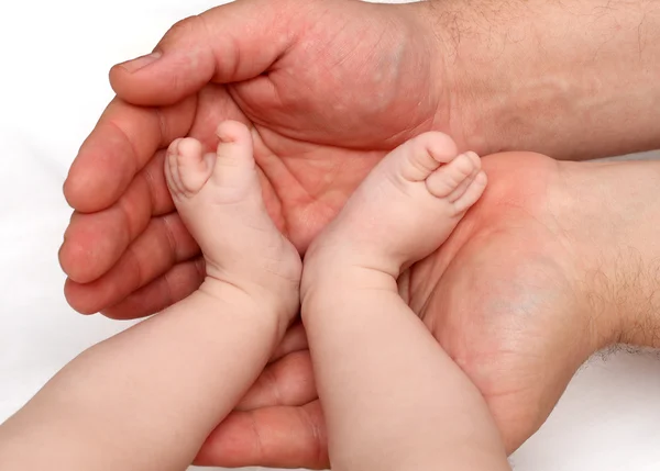 Pés de bebê em palmas do pai — Fotografia de Stock
