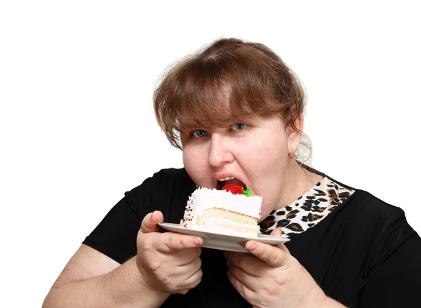 Overweight woman biting cake Stock Picture