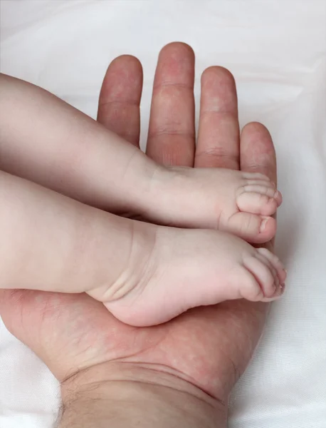 Babyfüße auf der Handfläche des Vaters — Stockfoto