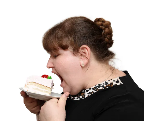 Overweight woman biting cake Royalty Free Stock Photos