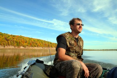 Man on inflatable boat with motor clipart