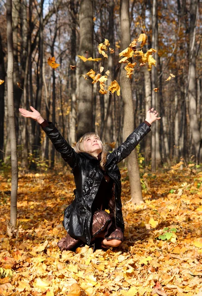 Красива дівчина кидає осіннє листя — стокове фото