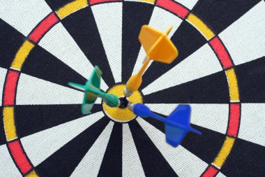 Dartboard with darts in aim clipart