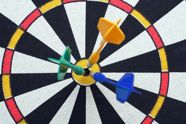 Dartboard with darts in aim — Stock Photo, Image
