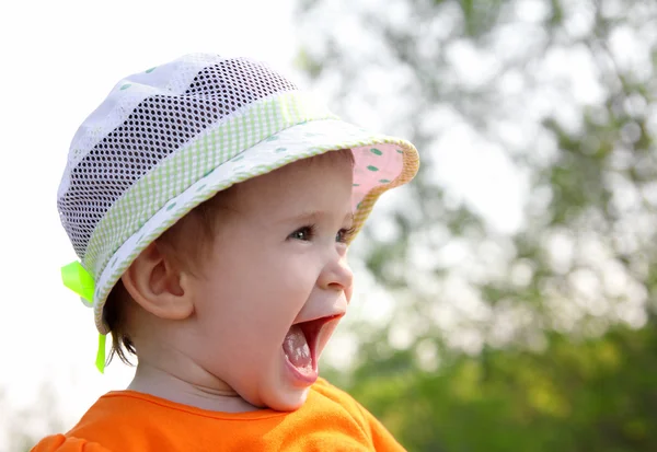Laughing baby in hoed buiten — Stockfoto