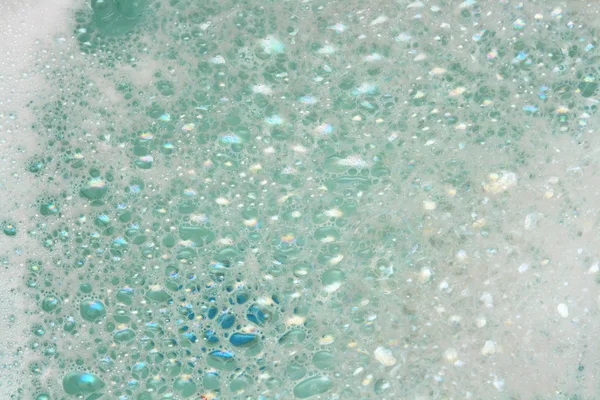 Espuma de jabón sobre agua azul — Foto de Stock