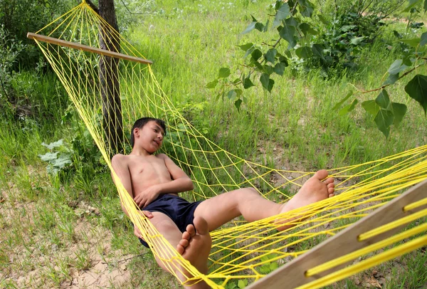 Menino relaxante em rede — Fotografia de Stock