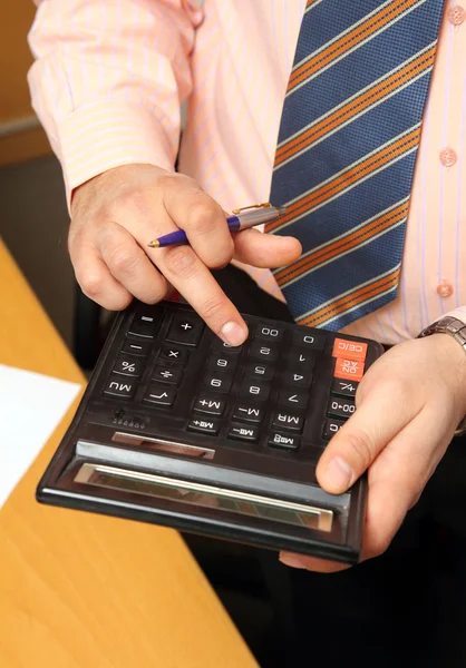 Empresario cuenta con dinero en calculadora — Foto de Stock