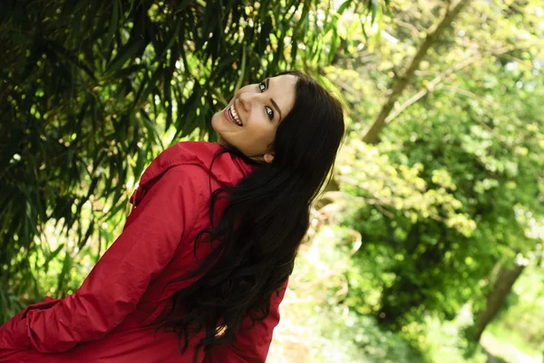 Dziewczyna w czerwony płaszcz w ogrodzie — Zdjęcie stockowe