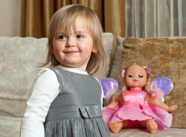 Sevimli küçük kız ve bir oyuncak bebek — Stok fotoğraf