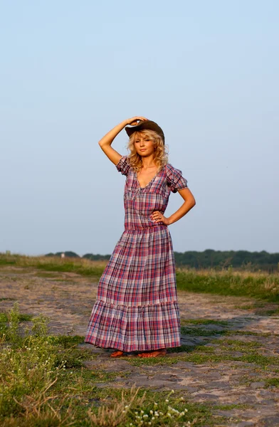 Krásná blondýnka v kovbojském klobouku a šaty — Stock fotografie