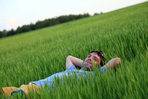 Молодой человек отдыхает на лугу — стоковое фото