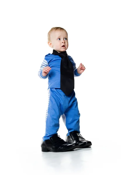 Маленький хлопчик на великому взутті — стокове фото