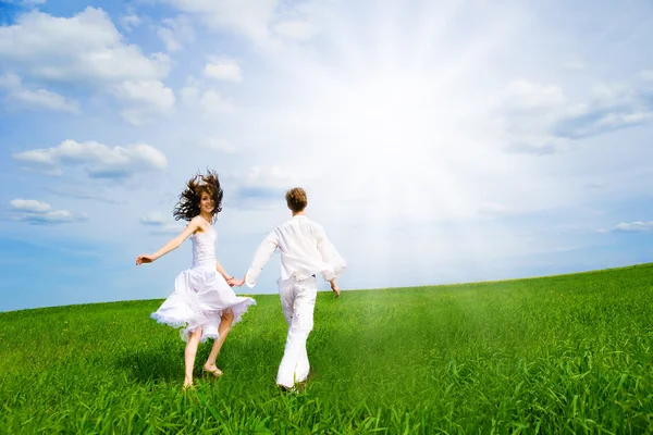 Couple holding hands in a field — Stock Photo, Image