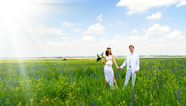Пара держащихся за руки в поле — стоковое фото