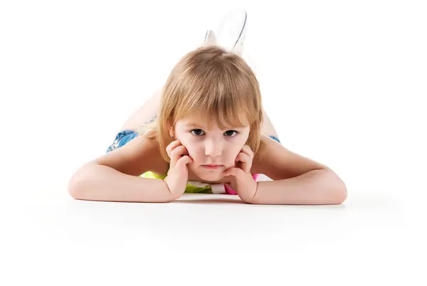 Süßes kleines Mädchen liegt auf dem Boden — Stockfoto